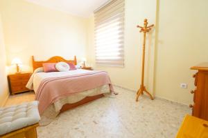um quarto com uma cama com uma cruz na parede em Casa Playa de Rota em Rota