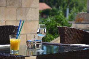 una copa de vino y un zumo de naranja en una mesa en Hotel Borik, en Lumbarda