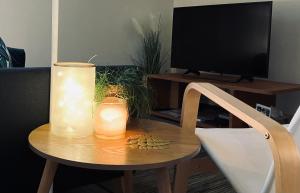 una mesa con 2 velas en una mesa con TV en Greenhouse en Sart-lez-Spa
