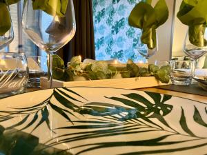 una mesa con vasos y un plato con una planta. en Greenhouse en Sart-lez-Spa