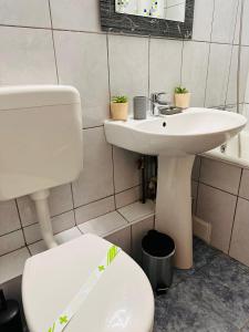 La salle de bains est pourvue de toilettes blanches et d'un lavabo. dans l'établissement Euro Apartment, à Bucarest