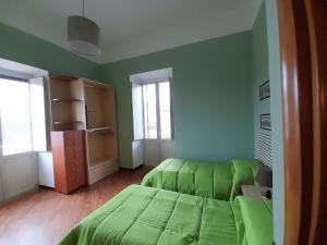 Dormitorio verde con cama verde y ventanas en MARTINI HOUSE, en Nápoles