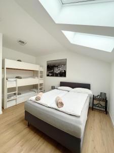 a bedroom with a bed with white walls and a skylight at Neue Moderne FeWo Europa-Park & Rulantica in Ringsheim