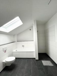 a bathroom with a toilet and a sink and a skylight at Neue Moderne FeWo Europa-Park & Rulantica in Ringsheim