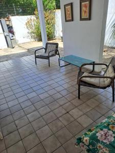 Duas cadeiras e uma mesa num pátio em azulejo em Casa aconchegante na zona leste em Teresina
