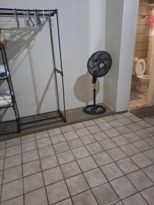 a bathroom with a fan on a tiled floor at Casa aconchegante na zona leste in Teresina