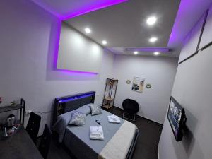 a room with a table and a tv and purple lights at Aircraft services rooms in Naples