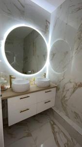 a bathroom with two sinks and a mirror at Golden House in Dreux