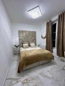 a bedroom with a large bed in a white room at Golden House in Dreux
