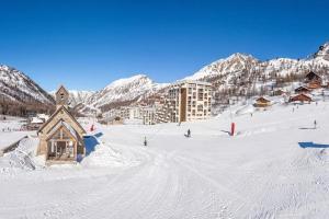 un lodge de ski dans la neige en face d'une montagne dans l'établissement Appartement Front de neige, à Isola