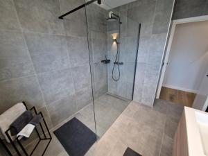 a bathroom with a shower with a glass door at Luxueus, ruim appartement op 350m van het strand in Ostend