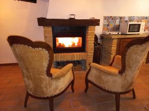 2 sillas en una sala de estar con chimenea en Ca' Marcella terra cielo tre livelli con soppalco, en Montetiffi
