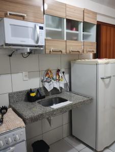 uma cozinha com um lavatório e um frigorífico branco em Studio FG hospedagem em Maceió