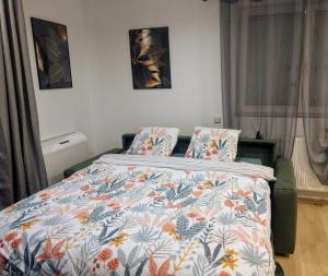 a bedroom with a bed with a colorful comforter at Appartement proche d'Europa park/Marchés de Noël in Rhinau