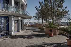 a walkway next to a building with the ocean in the background at Sfumato Rooms in Odesa
