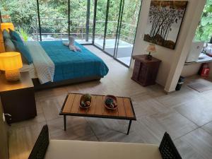 a living room with a bed and a coffee table at Mindo Garden Lodge and Wildlife Reserve in Mindo