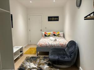 a bedroom with a bed and a chair at Double room with shares bathroom in Woolwich
