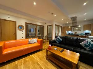 a living room with an orange couch and a table at The Noko 2 Bedroom Apartment Central London by Wild Boutique in London
