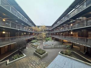 a large building with a courtyard with trees in it at The Noko 2 Bedroom Apartment Central London by Wild Boutique in London