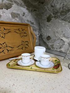 dos tazas de té y platillos sentados en una bandeja en Kroi'Pistolve, en Krujë
