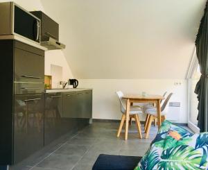 una pequeña cocina y una mesa en una habitación en Greenhouse en Sart-lez-Spa