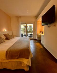 a bedroom with a large bed with a flat screen tv at Maison R Boutique in Reggio di Calabria