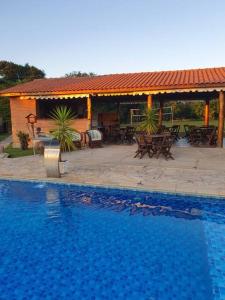una piscina frente a una casa con patio en Espaço Maria Carolina, en São Pedro