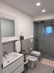 uma casa de banho com um lavatório branco e um WC. em Appartamento Casa Roby em Montecatini Terme