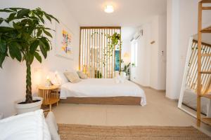 a bedroom with a bed and a potted plant at Naim Playa in Cala del Moral