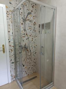 トゥズラにあるZen Apartment Tuzlaの浴室のガラス扉付きシャワー +5枚の写真