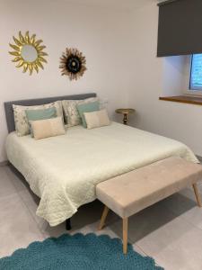 um quarto com uma cama grande e um banco. em Appartamento Casa Roby em Montecatini Terme