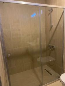 y baño con ducha de cristal y aseo. en Furnished APT (29th floor) with panoramic views, en Esenyurt