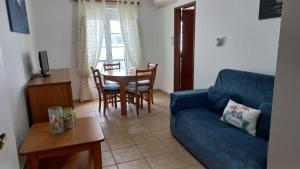 a living room with a blue couch and a table at Paradise in Cabanas de Tavira in Cabanas de Tavira