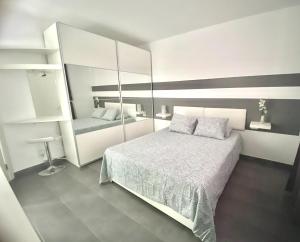 Perfect Sunset II في بويرتو دي لا كروث: غرفة نوم بيضاء مع سرير ومرآة