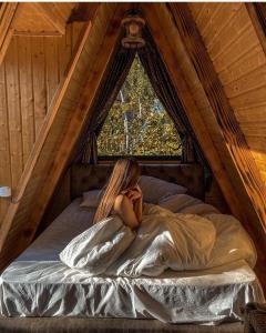 una mujer acostada en una cama en un ático en HillSide Cottage en K'eda