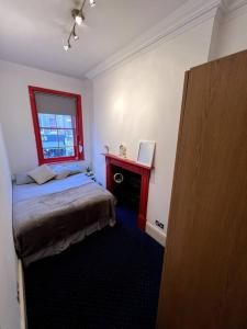 a small bedroom with a bed and a window at Flat in Central London in London