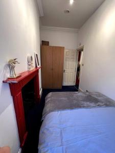 ein kleines Schlafzimmer mit einem Bett und einem roten Tisch in der Unterkunft Flat in Central London in London