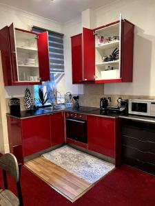 a kitchen with red cabinets and a stove top oven at Flat in Central London in London