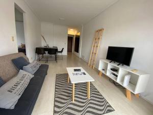 a living room with a couch and a tv and a table at Tigre Center Tower B - Con parking, piscina y seguridad 24hs in Tigre