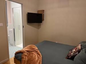 um quarto com uma cama e uma televisão de ecrã plano em Studio de charme avec terrasse privée em Bouxwiller