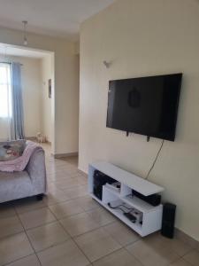 een woonkamer met een flatscreen-tv aan de muur bij KMA APARTMENTS BLOCK 10-3 in Mtwapa