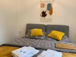 a bed with yellow pillows on top of it at LOFT-LUX Apartment in Jelenia Góra