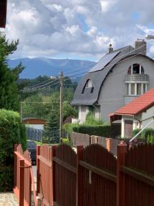 a fence in front of a house with mountains in the background at LOFT-LUX Apartment in Jelenia Góra +14 photos