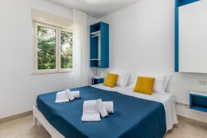a bedroom with a blue and white bed with yellow pillows at Calanca Apulian Residence in Torre Santa Sabina +26 photos