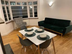 a living room with a table and a green couch at Superb 2 Bedrooms Ealing Broadway Apartment next to Tube & Buses in Ealing