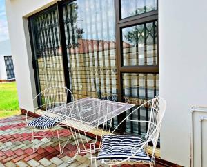 a table and two chairs sitting on a patio at Luxury Garden Cottage in Welkom in Welkom