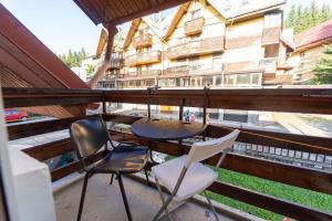 een balkon met een tafel en stoelen en een gebouw bij Vila Veverita in Predeal