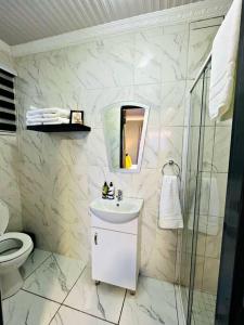 a white bathroom with a sink and a shower at Luxury Garden Cottage in Welkom in Welkom +24 photos