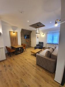 un soggiorno con un divano e un tavolo di MASSIV Kopaonik centar lux apartmani a Kopaonik