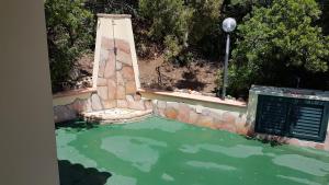 a pool of water with a stone wall and a fountain at Villetta Mari Pintau in Geremèas
